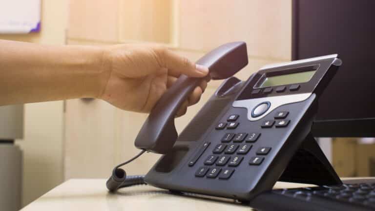 person picking up the phone to make a call