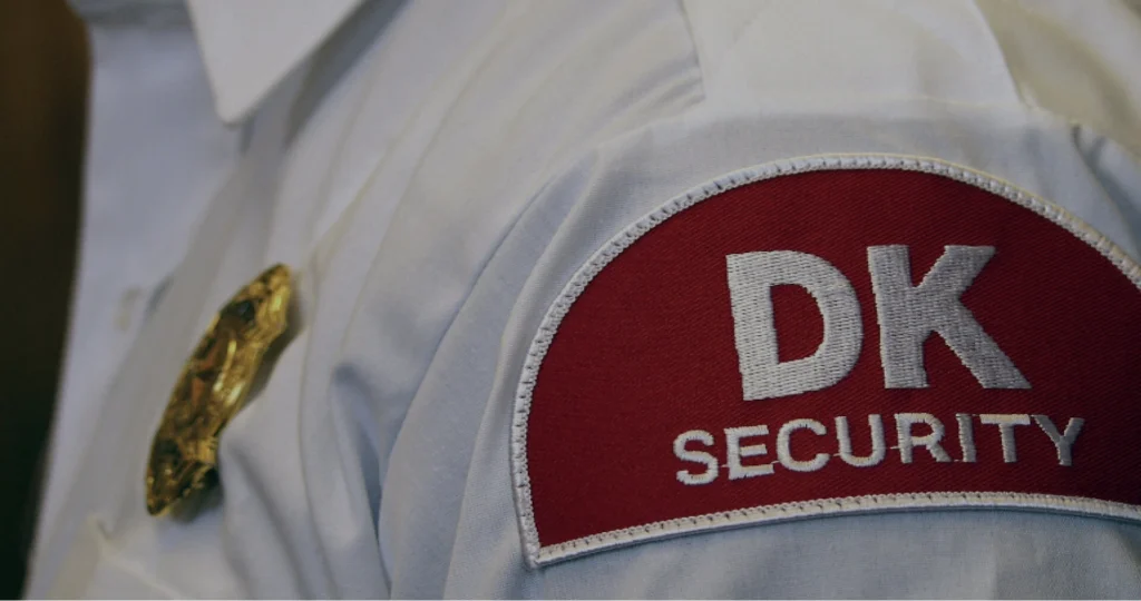 The DK Security logo on a shoulder patch worn by a uniformed security officer
