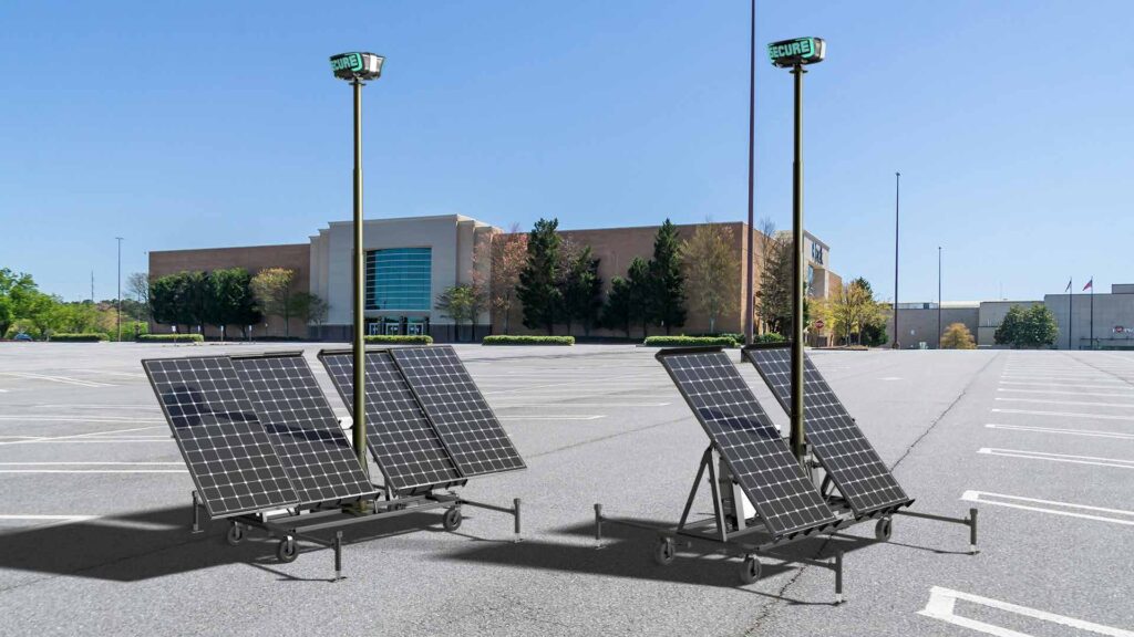 Two RIO solar powered AI robotic device towers stand post in an open parking lot