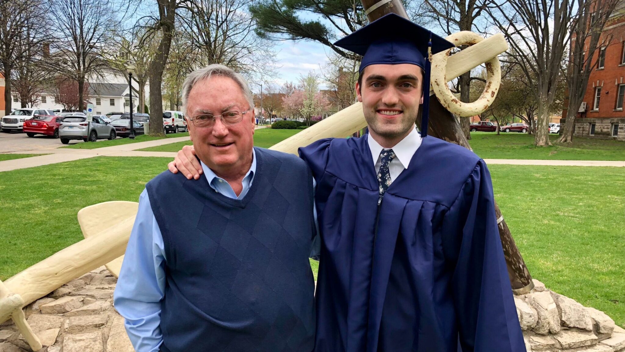 Johnny and father John Kendall pose in front of a Hope College monument at the Holland college campus following Johnny's college graduation.