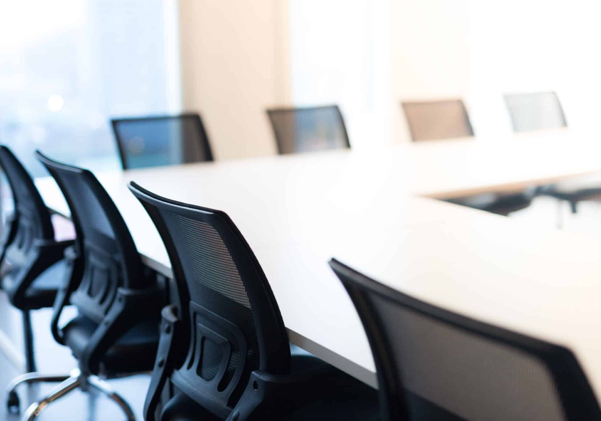 Modern meeting room with large windows, view back chair, outside building, city, tower view, soft focus.