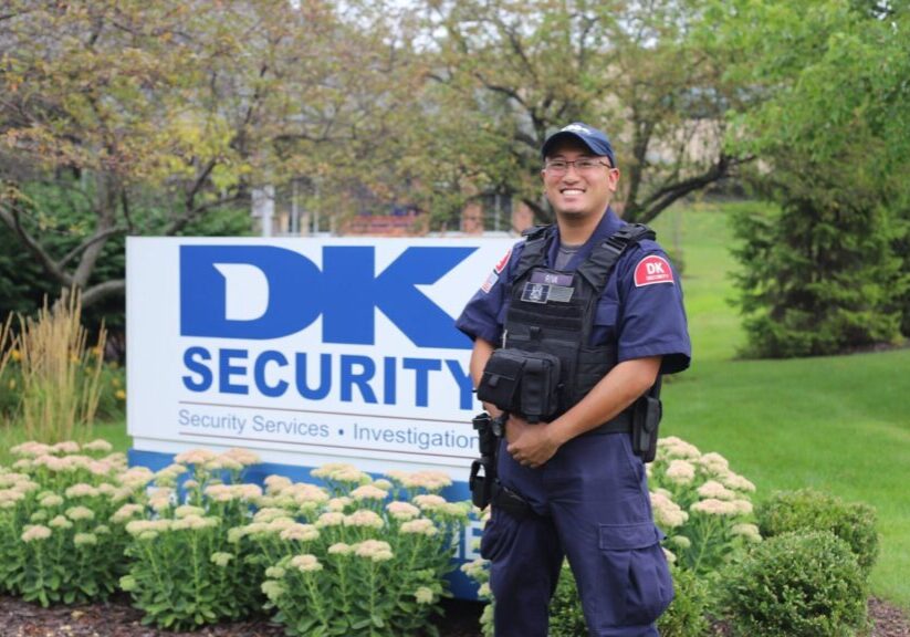 Armed security personnel standing in front of DK Security sign