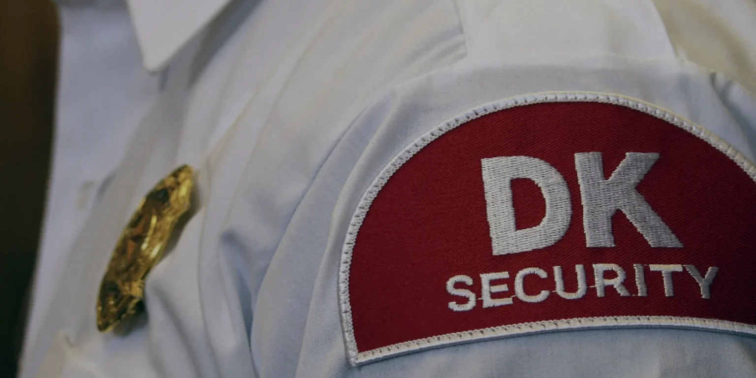 The DK Security logo on a shoulder patch worn by a uniformed security officer